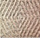 Eine Nahaufnahme eines gewebten Stoffes mit einem Zickzackmuster. Die Textur ist komplex und das Gewebe ist eng, was ihm ein glattes Aussehen verleiht.