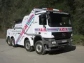 Ein weißer Abschleppwagen mit dem Wort 'HAiM' auf der Seite und vorne. Er hat ein Ersatzrad hinten und ist am Straßenrand geparkt.
