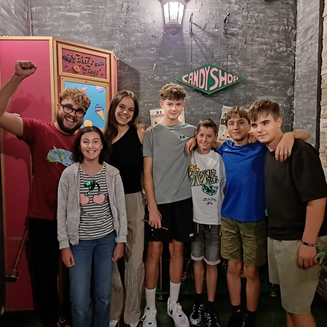 Eine Gruppe junger Leute posiert für ein Foto vor einer Candy Shop-Fotokabine.