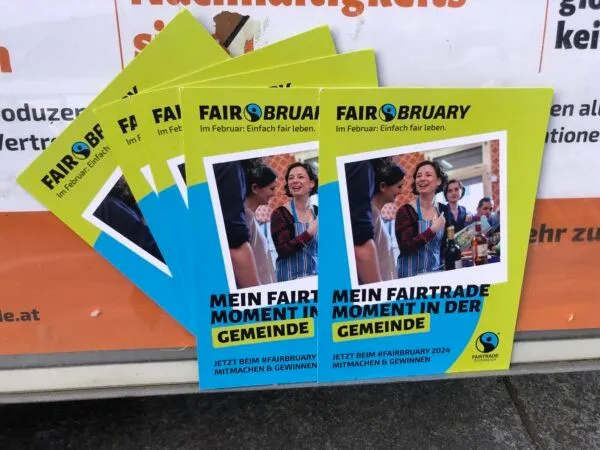 Vier grün-gelbe Flyer werben für 'Mein Fair Trade Moment in der Gemeinde' mit Bildern lächelnder Frauen. Sie fördern die Teilnahme an der 'Fair Februar'-Kampagne.