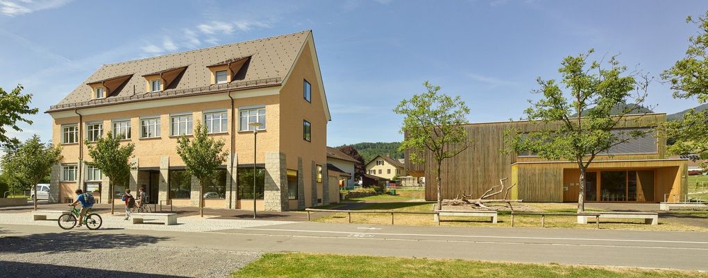  Abschnitt Bild: Ein großes gelbes Gebäude mit mehreren Fenstern und einem Giebeldach befindet sich in einer ländlichen Gegend.