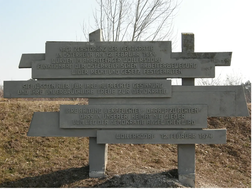 Ein Denkmal in Wöllersdorf, Österreich, erinnert an die Zerstörung der Demokratie am 12. Februar 1934. Es ehrt die österreichische Arbeiterbewegung für ihren Widerstand gegen das Gesetz und die Ordnung. Die Tafeln fordern Besucher auf, an ihre aufrechte Haltung für die Demokratie zu erinnern.