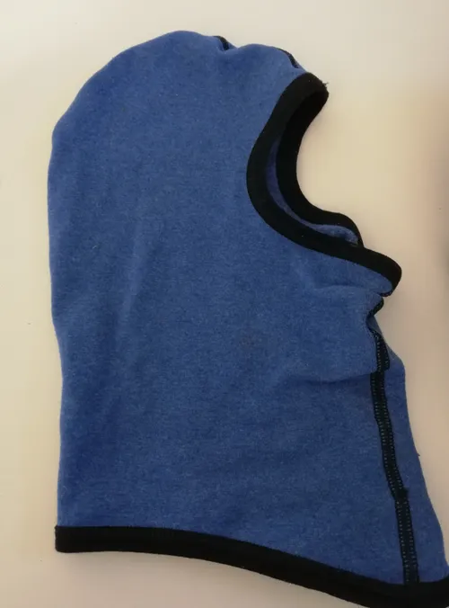 Eine Nahaufnahme eines blauen Winter-Balaclavas mit schwarzem Rand, präsentiert auf einem weißen Hintergrund.