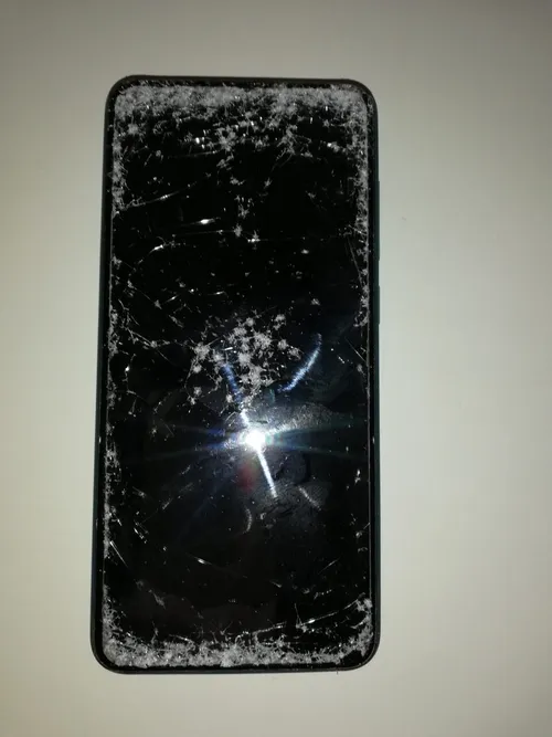 Ein Handy mit zerbrochenem Bildschirm auf weißem Hintergrund.