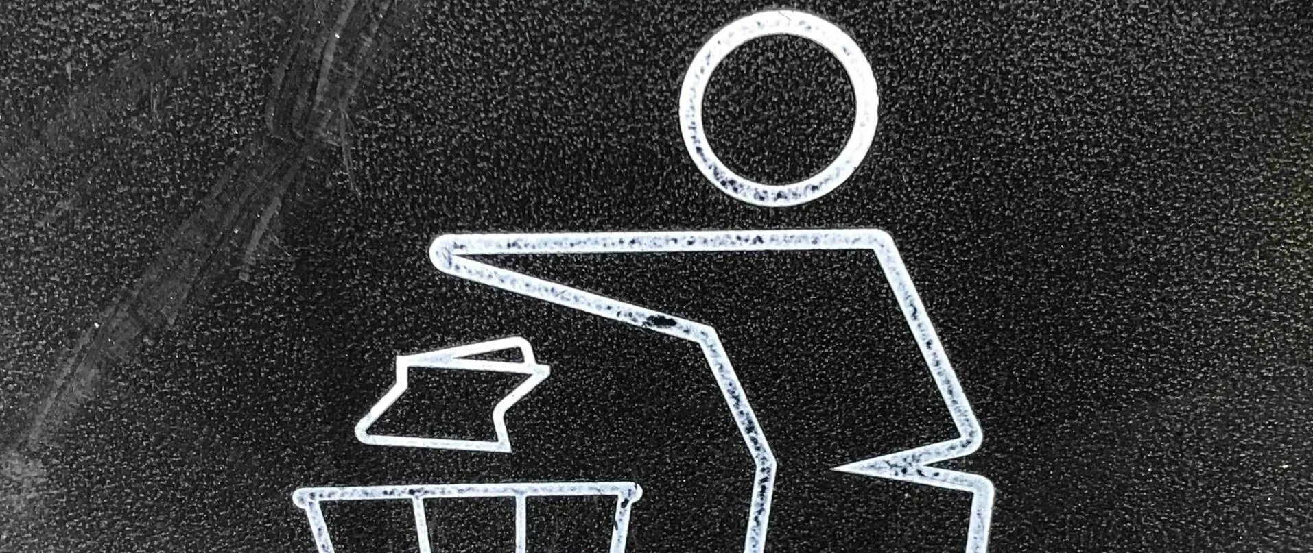 Ein schwarzer Hintergrund mit einem weißen Symbol einer Person über einem Schreibtisch, einem Stück Papier und einem Mülleimer.