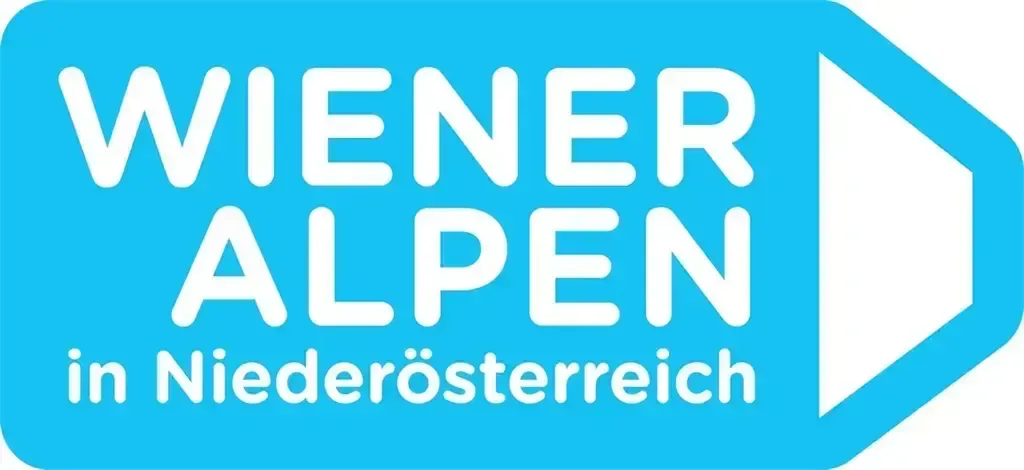 Das Logo der Wiener Alpen in Niederosterreich, mit weißem Text auf blauem Hintergrund und einem weißen Pfeil nach rechts.