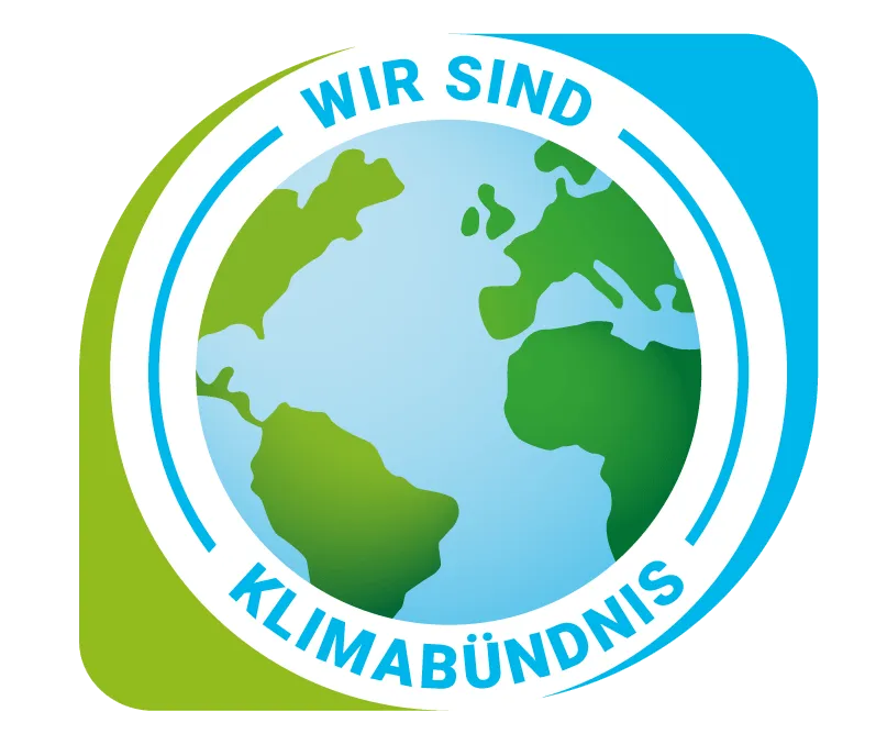 Das Bild zeigt ein Logo mit einer Erdkugel und dem Text 'WIR SIND KLIMABUNDNIS'. Das Design ist kreisförmig mit einem blauen und weißen Rand.