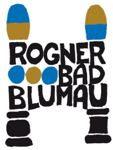 Ein Bild mit dem Text 'ROGNER BAD BLUNAU' prominent dargestellt. Das Wort 'ROGNER' ist in fetten schwarzen Buchstaben über zwei stilisierten Beinen geschrieben, einem blauen und einem braunen, das andere blau und braun. Unter 'ROGNER' stehen die Worte 'BAD BLUNAU' in ähnlicher Stil.