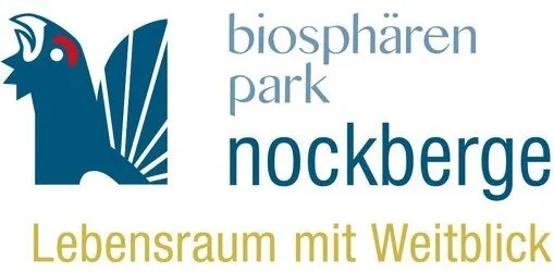 Logo für den Biosphärenpark Nockberge, mit einem blauen Vogel, blauem Text und der Phrase 'Lebensraum mit Weitblick' in Gelb.