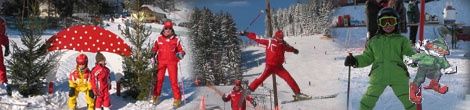 Eine Gruppe von Menschen in roten und grünen Skianzügen steht und fährt auf einem verschneiten Hang. Einige sind im Freien, andere in der Luft. Im Hintergrund ist ein Weihnachtsbaum und ein Haus zu sehen.