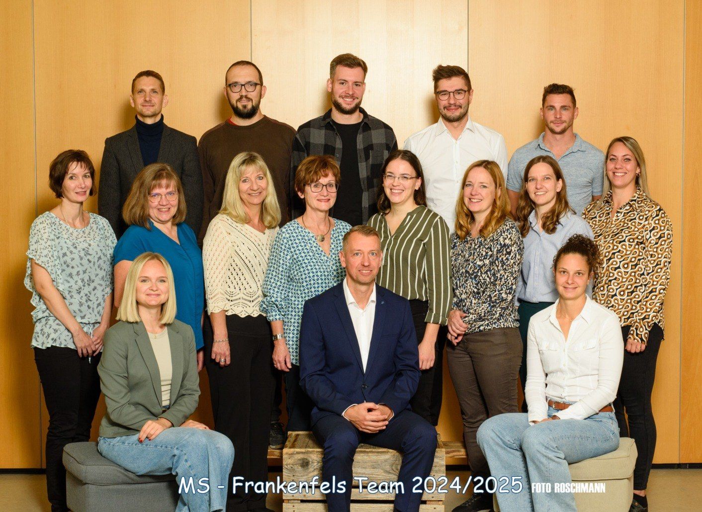 Gruppenfoto des MS-Frankenfels-Teams für die Jahre 2024/2025. Das Team steht und sitzt auf Holzkisten vor einer Holzwand.