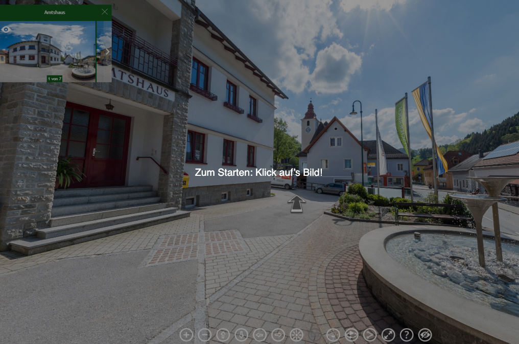Bild eines Stadtplatzes mit einem Gebäude und einem Brunnen. Eine Nachricht auf Deutsch lautet Zum Starten: Klick auf's Bild!