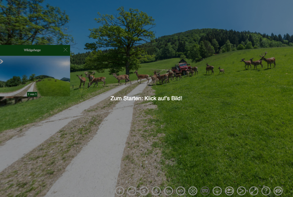 Ein grasbewachsenes Feld mit grasenden Hirschen und einem roten LKW im Blick. Ein Wasserzeichen lautet: 'Zum Starten: Klick aufs Bild!'.