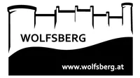Ein schwarz-weißes Logo mit dem Wort Wolfsberg und einer Website-URL, www.wolfsberg.at, wird auf schwarzem Hintergrund angezeigt.