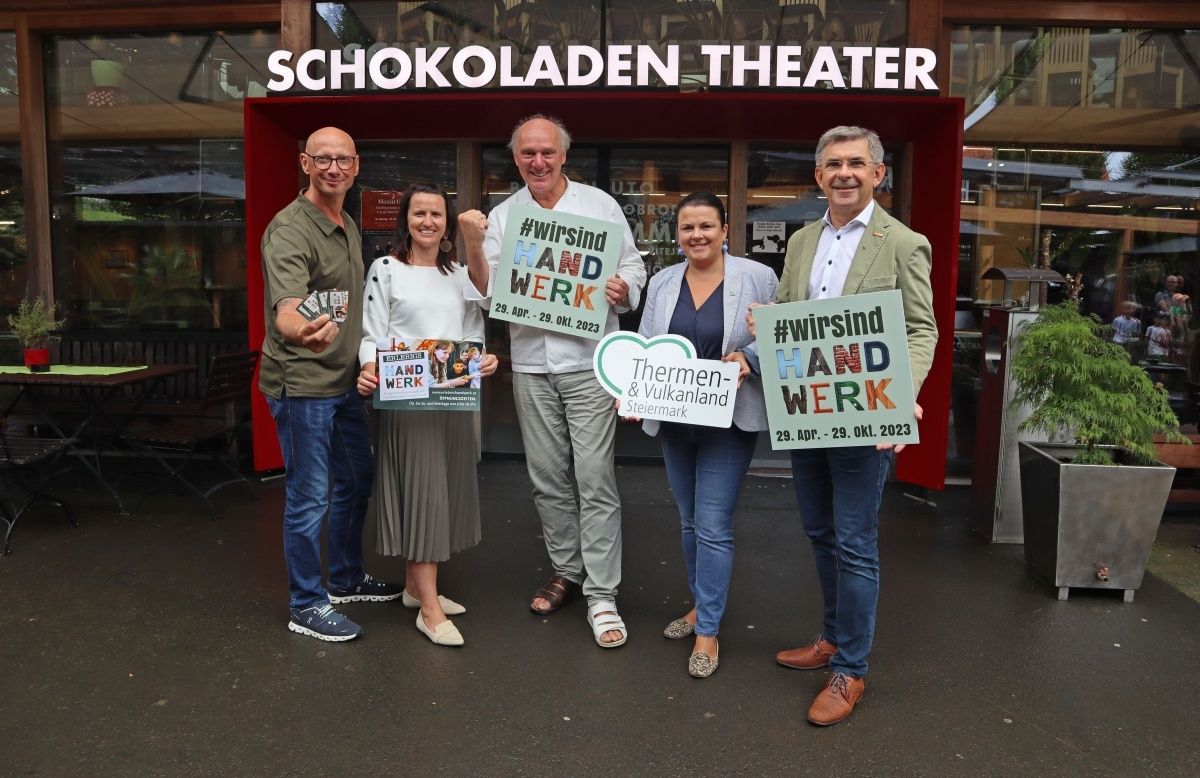 Vier Personen stehen vor dem Schokoladen Theater und halten Schilder mit dem Hashtag #wirsindhandwerk und den Daten vom 29. April bis 29. Oktober 2023.