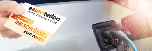 Eine Hand hält eine eautotein-Karte neben einem Auto, das an einer Ladestation aufgeladen wird. Die Karte zeigt 'Ihr Schlüssel zum eauto'.