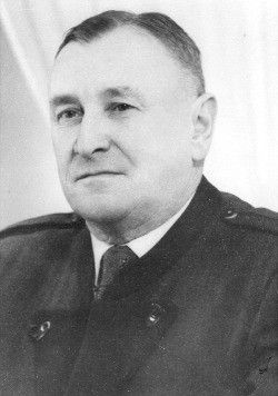 Schwarz-Weiß-Foto eines ernst aussehenden Mannes in Militäruniform, wahrscheinlich ein Offizier, mit ernster Miene und Licht, das auf sein Gesicht fällt.