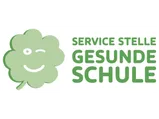 Ein grünes Kleeblatt mit einem lächelnden Gesicht und dem Text 'SERVICE STE GESUN SCHUL' in grüner Schrift.