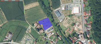 Luftbild eines Grundstücks mit Gebäuden und einem Parkplatz. Das Grundstück ist durch grüne Linien unterteilt, wobei einige Zahlen und Buchstaben auf der Karte markiert sind. Gebäude sind in Rot dargestellt, und es gibt einen blau schattierten Bereich mit der Nummer 438/5.