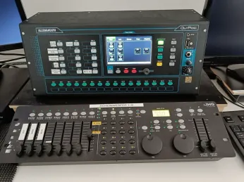 Eine schwarze Allen&Heath digitale Mischkonsole mit Bildschirm und zahlreichen Tasten, auf einem Dimmer-Controller platziert.