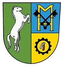 Das Wappen zeigt ein aufgerichtetes weisses Pferd links, einen blau-gelben Schild mit dem Buchstaben M in der Mitte und ein Zahnradsymbol rechts.