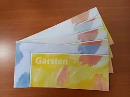 Ein Stapel von vier bunten Karten mit der Aufschrift 'Garsten' auf der Vorderseite, auf einem Holztisch platziert. Die Karten haben verschiedene Farben und Muster.