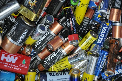 Eine Sammlung verschiedener Batterien, einschließlich Duracell, Energizer und Eveready, einige mit Etiketten, die verschiedene Größen und Typen angeben. Sie sind meist zylindrisch, wobei einige Schutzkappen haben.