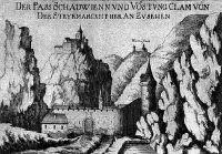 Eine Schwarz-Weiß-Zeichnung zeigt eine Burg auf einem Hügel mit einem kleinen Gebäude in der Nähe, vor einer bergigen Kulisse.