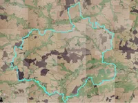 Eine Karte mit verschiedenen Grün-, Braun- und Beigetönen zeigt eine blau umrissene Region. Das Gebiet hat eine Mischung aus ländlichen und bewaldeten Landschaften.