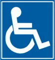 Ein blaues Schild mit einem weißen Rollstuhlsymbol, das auf einen rollstuhlgerechten Bereich hinweist.