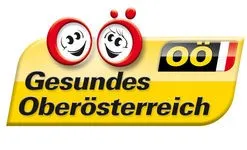 Ein gelbes Schild mit zwei lächelnden Gesichtern und den Worten 'Gesundes Oberösterreich' unter einem roten 'oo' Logo.