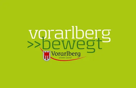 Das Logo von 'Vorarlberg bewegt' zeigt einen grünen Hintergrund mit weißem Text und einem roten Pfeil, der nach links zeigt. Die Worte 'Vorarlberg bewegt' sind in fetter weißer Schrift, während 'unser Land' in kleinerer weißer Schrift darunter steht.