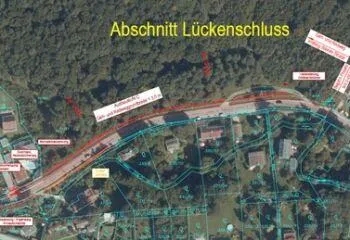 Eine Luftaufnahme eines Ortes namens Luckenschluss. Es zeigt eine Straße, mehrere Häuser und einen Wald. Es gibt mehrere beschriftete Linien und Kästen, die bestimmte Bereiche kennzeichnen.
