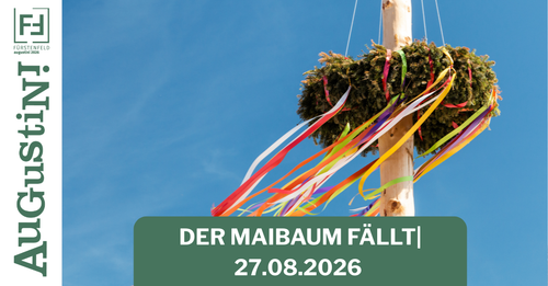 Ein Holzpfahl mit bunten Bändern, die daran hängen. Der Text 'DER MAIBAUM FALLT| 27.08.2026' steht unter dem Pfahl. Der Himmel ist klar und blau.
