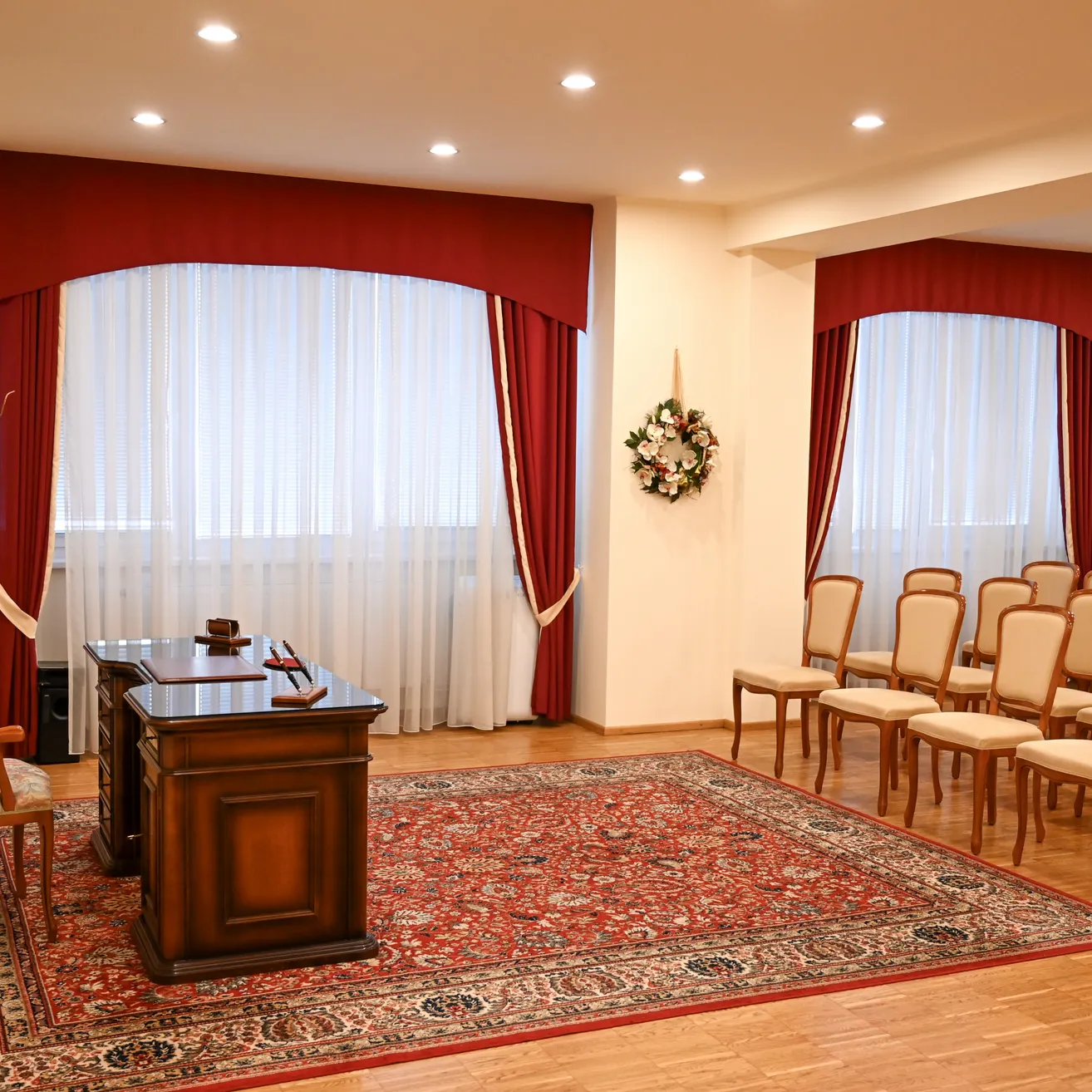 Ein leerer Konferenzraum mit einem Holztisch, einer Blumendekoration und einem Teppich.