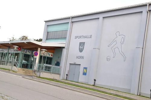 Ein großes Gebäude mit den Worten Sporthalle Horn an der Wand. Ein Fußballspieler und ein Fußball sind auf der Wand gezeichnet.