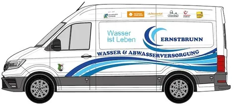 Ein weißer Lieferwagen mit blauen und weißen Wellen auf der Seite, beschriftet mit 'Wasser ist Leben' und 'ERNSTBRUNN WASSER & ABWASSERVERSORGUNG'