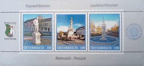 Eine Reihe von drei österreichischen Briefmarken mit einer Statue, einem Brunnen und einem Gebäude.