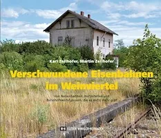 Ein altes, verlassenes Haus steht mitten in einem Feld, umgeben von überwuchertem Gras und Pflanzen. Das Haus sieht abgenutzt aus, einige Teile des Daches fehlen.