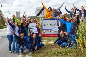 Eine Gruppe von Menschen posiert für ein Foto vor einem Schild mit der Aufschrift 'Ernstbrunn'.