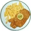 Ein Teller mit gebratenem Fisch, einer Zitronenscheibe und Pommes Frites auf einem weißen Teller mit grünem Rand.