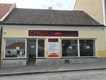 Ein Ladengeschäft mit einem roten Dach und gelben Wänden. Das Schild sagt 'Finger's' in roten Buchstaben, mit einem Autologo darunter.