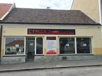 Ein Laden mit einem roten Dach und gelben Wänden. Das Schild sagt 'E.Fingers Kratzitzel'. Es gibt drei Glasfenster mit roten Autoaufklebern.