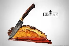 Ein Messer mit einem Holzgriff liegt auf einem Stück Käse, wobei der Markenname 'Lilienthal' oben sichtbar ist.