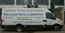 Ein weißer Lieferwagen mit der Aufschrift 'WALLNER METALLARBEITEN' vor einem Gebäude geparkt.
