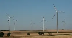 Ein Feld mit mehreren Windturbinen unter einem klaren blauen Himmel.
