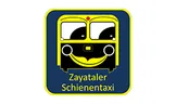Ein Cartoon-Stil Bus mit einem lächelnden Gesicht, gelb und schwarz in Farbe, beschriftet 'Zaytater Schienentaxis'.