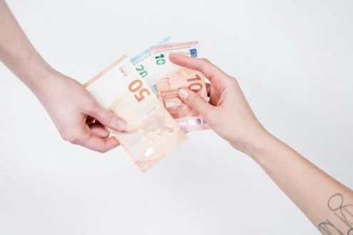 Zwei Hände tauschen eine 50-Euro-Note und eine 10-Euro-Note aus. Die Scheine stehen im Fokus, mit weißem Hintergrund und klarer Beleuchtung.